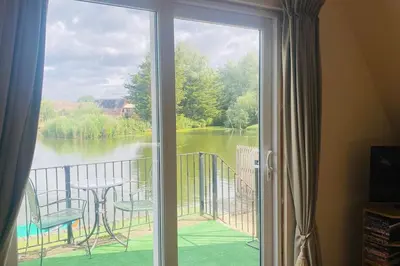 a sliding glass door with a view of a lake at River Lark Lodge in Ely