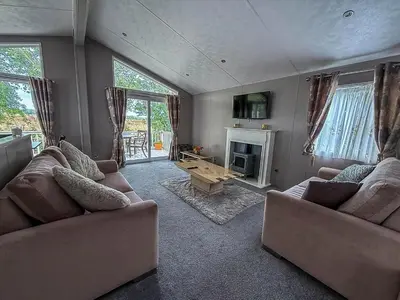 a living room with two couches and a fireplace at Stunning Lodge With Decking At Oaklands Holiday Park In Essex Ref 39017Rw in Clacton-on-Sea