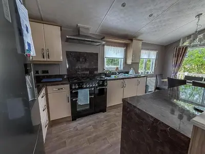 a kitchen with a stove and a counter top at Stunning Lodge With Decking At Oaklands Holiday Park In Essex Ref 39017Rw in Clacton-on-Sea