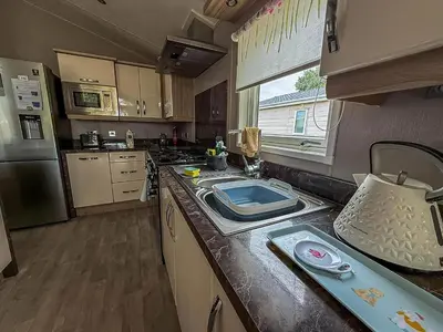 a kitchen with a sink and a counter top at Stunning Lodge With Decking At Oaklands Holiday Park In Essex Ref 39017Rw in Clacton-on-Sea