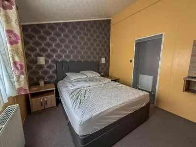 a bedroom with a large bed in a room at Stunning Lodge With Decking At Oaklands Holiday Park In Essex Ref 39017Rw in Clacton-on-Sea