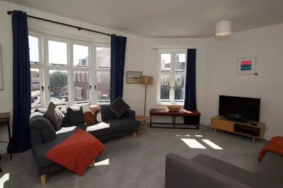 a living room with a couch and a tv at Beautiful large 3-bed coastal flat with parking. in Frinton-on-Sea