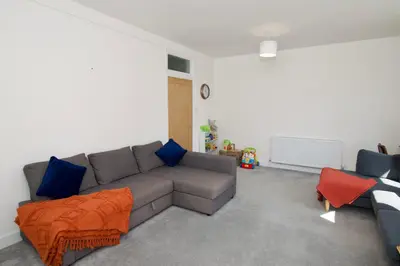 a living room with a gray couch and blue pillows at Beautiful large 3-bed coastal flat with parking. in Frinton-on-Sea