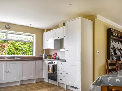 a kitchen with white cabinets and a window at An Croke in Higham