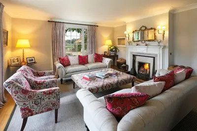 a living room with a couch and a fireplace at Butley Priory Farmhouse 12 in Woodbridge