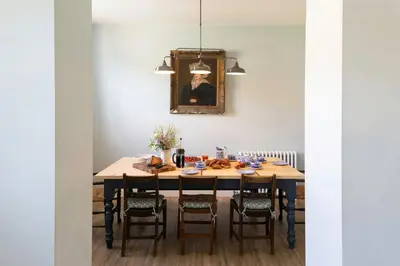 a dining room with a wooden table and chairs at Butley Priory Farmhouse 12 in Woodbridge