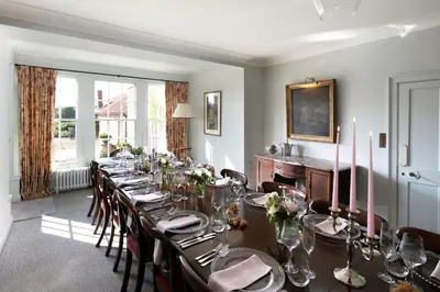a long dining room with a long table and chairs at Butley Priory Farmhouse 12 in Woodbridge