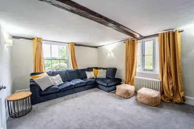 a living room with a blue couch and yellow curtains at 5 Bed Farmhouse Suitable for Contractors Private Parking in Potter Street