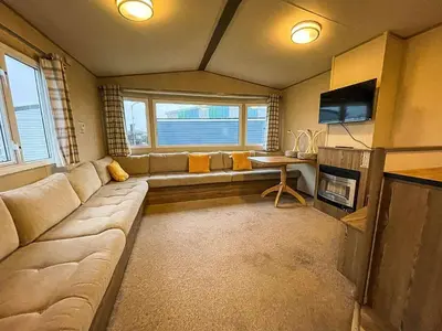 a living room with a large couch and a table at Seawick Caravan 922 in Clacton-on-Sea