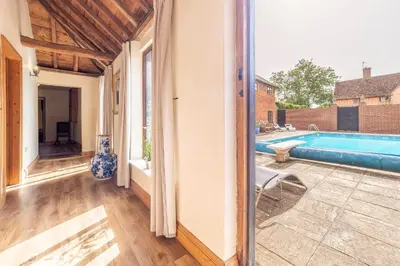 a house with a swimming pool and a patio at Stable Cottage in Semer