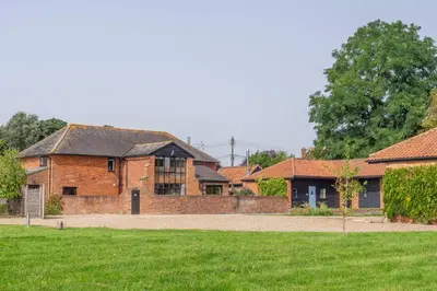 an old brick house with a yard and grass at Stable Cottage in Semer