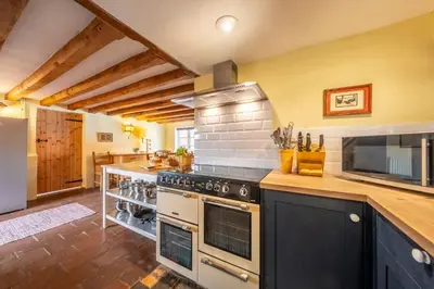 a large kitchen with a stove and a microwave at The Old Barn in Semer