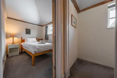 a small bedroom with a bed and a window at The Old Barn in Semer
