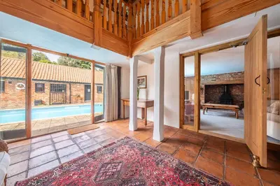 an open living room with a view of a pool at Semer Barn in Semer