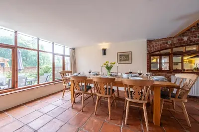 a dining room with a wooden table and chairs at Semer Barn in Semer