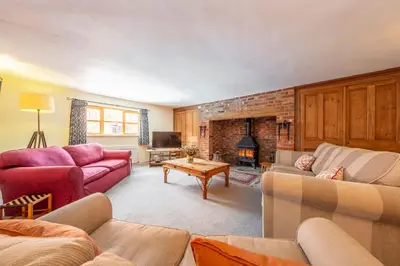a living room with two couches and a fireplace at Semer Barn in Semer