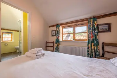 a bedroom with a white bed and a window at Semer Barn in Semer