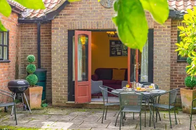 a table and chairs in front of a house at Semer Barn in Semer
