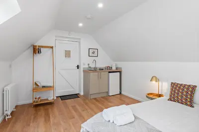 a white bedroom with a bed and a desk at Attractive 2 storey, 2 bedroom barn in Long Melford in Long Melford