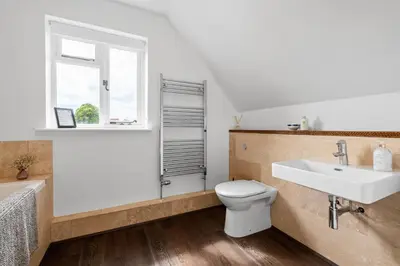 a bathroom with a sink and a toilet and a window at Attractive 2 storey, 2 bedroom barn in Long Melford in Long Melford