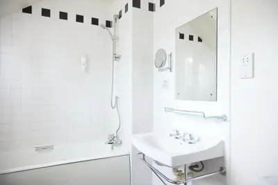 a white bathroom with a sink and a shower at Bell by Greene King Inns in Thetford