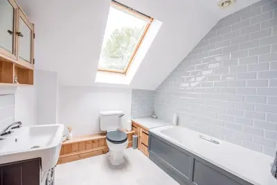 a bathroom with a sink and a toilet and a window at The Old Coach House, Leiston in Leiston