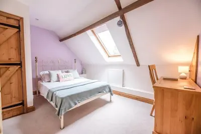 a bedroom with a bed and a window at The Old Coach House, Leiston in Leiston