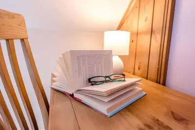 a stack of books and a pair of glasses on a table at The Old Coach House, Leiston in Leiston