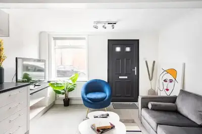 a living room with a couch and a blue chair at Nice 2 bedroom house in Stowmarket in Stowmarket