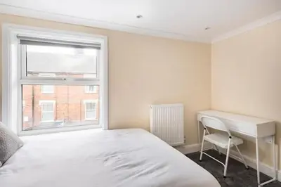 a bedroom with a bed and a desk and a window at Nice 2 bedroom house in Stowmarket in Stowmarket
