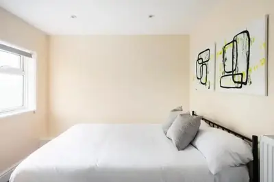 a white bedroom with a large bed and a window at Nice 2 bedroom house in Stowmarket in Stowmarket
