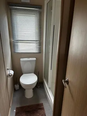 a small bathroom with a toilet and a window at Happy Place in West Mersea