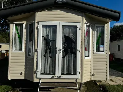 a small shed with a spider man reflection in the window at Happy Place in West Mersea