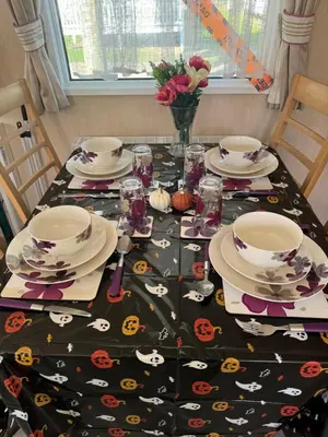 a table with a table cloth with pumpkins on it at Happy Place in West Mersea