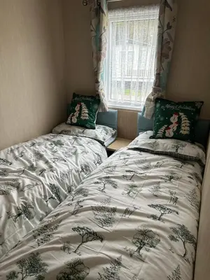 a bedroom with two twin beds and a window at Happy Place in West Mersea