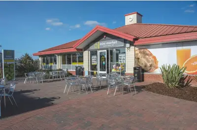 a restaurant with tables and chairs in front of a building at Brand New Modern Holiday Home - Haven The Orchards Holiday Park in Saint Osyth