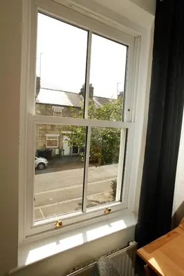 a window with a view of a street at Vibrant Mill Road Oasis - Peaceful House with Garden near station in Cambridge