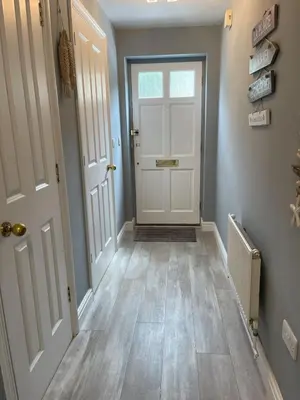 a hallway with a white door and wooden floors at Vibrant Mill Road Oasis - Peaceful House with Garden near station in Cambridge