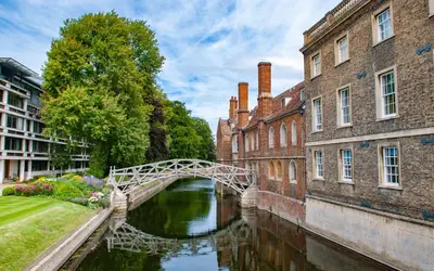 a bridge over a river between two buildings at Vibrant Mill Road Oasis - Peaceful House with Garden near station in Cambridge