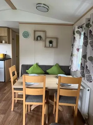 a dining room table with chairs and a couch at Lovely place in Saint Osyth