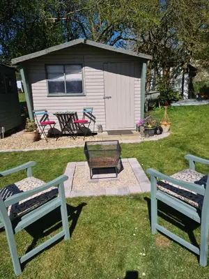 a backyard with two benches and a fire pit at The Potting Shed in Manuden