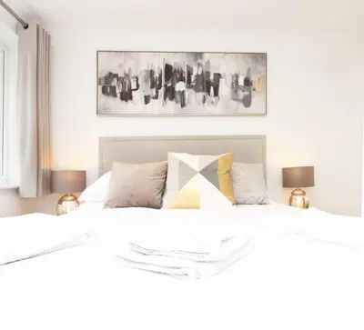 a bedroom with a large white bed with two lamps at Modern and Cosy Flat For 4 in Cherry Hinton
