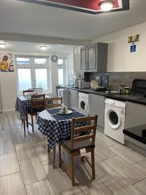 a kitchen with a table and chairs in a kitchen at Penn Gardens Flat 1 - 2 - 3 & 4 Apartments in Havering atte Bower