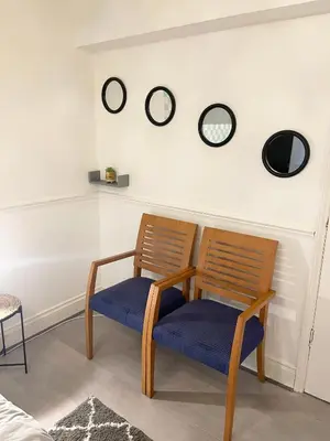 a room with two chairs and clocks on the wall at Penn Gardens Flat 1 - 2 - 3 & 4 Apartments in Havering atte Bower