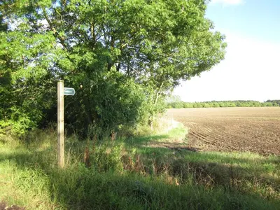 a sign in a field next to a tree at Colston Hall Cottages in Framlingham