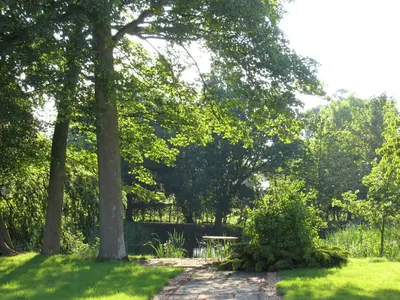 a picnic table in a park with trees and grass at Colston Hall Cottages in Framlingham