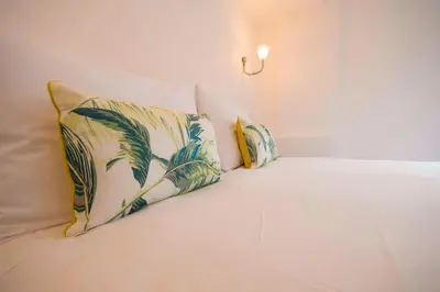 a white bed with two pillows on it at Dog and Whistle Pub in Hertford