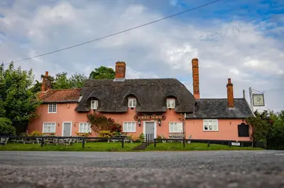 a large house with a thatched roof on a street at The Thatched Flat at The Sorrel Horse in Shottisham