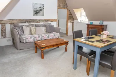 a living room with a couch and a table at The Thatched Flat at The Sorrel Horse in Shottisham