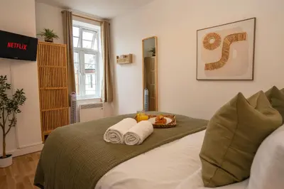 a bedroom with a bed with towels and a basket of fruit at Boho Style - KING BED, Central, Super FAST Wi-Fi in Cambridge